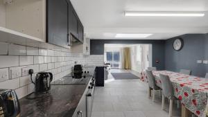 a kitchen with a table and a clock on the wall at Place to stay in Longbridge in Barking