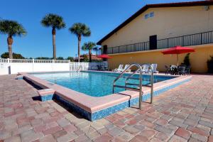 une piscine avec un escalier menant à un bâtiment dans l'établissement Americas Best Value Inn Ocean Inn, à Saint Augustine Beach