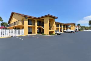 a large yellow building with a parking lot at Americas Best Value Inn St. Augustine in Saint Augustine Beach