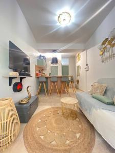 uma sala de estar com um sofá e uma mesa em Appart 1 chambre intra-muros avec JARDIN em Avignon