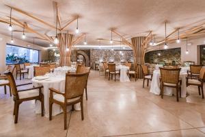 a dining room with white tables and chairs at Ratxó Retreat Hotel, member of Meliá Collection in Puigpunyent