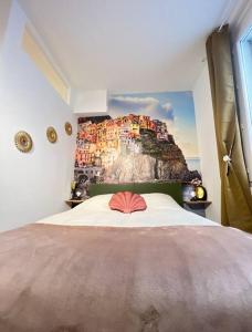 um quarto com uma cama grande e uma pintura na parede em Appart 1 chambre intra-muros avec JARDIN em Avignon