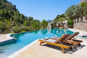 a pair of lounge chairs next to a swimming pool at Finca Ratxo Hotel, member of Melia Collection in Puigpunyent