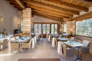 a dining room with tables and chairs and windows at Ratxó Retreat Hotel, member of Meliá Collection in Puigpunyent