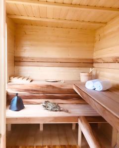 uma sauna de madeira com prateleiras de madeira e toalhas em Heaven Reset & Spa - Domek nad rzeka em Korczew