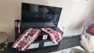 a living room with a table with a tv at Sea side apartment in Loutraki +5 photos