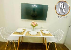 een witte tafel met twee stoelen en een vaas met bloemen bij M Haven in Manilla