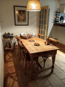 a wooden table in a kitchen with chairs and a light at Clos des Loriots in Queyrac