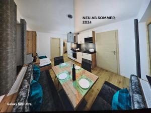 a living room with a dining table and a kitchen at Appartementhaus Eisbauer in Sankt Johann im Pongau