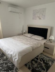 1 dormitorio con 1 cama grande con sábanas blancas en Villa Daniela en Loutráki