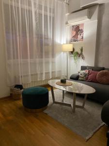 a living room with a table and a couch at Apartman Bella Novi Beograd in Bežanija