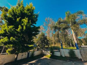 dos palmeras y una valla en un parque en Thevitisvillas, en Sultan Bathery