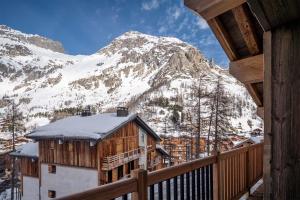 a view of a snow covered mountain from a balcony at Madame Vacances Chalet Arda in Le Joseray