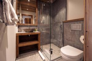 La salle de bains est pourvue d'une douche, de toilettes et d'un lavabo. dans l'établissement Madame Vacances Chalet Arda, à Le Joseray
