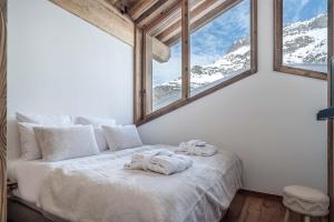 a bedroom with a bed with snow covered mountains at Madame Vacances Chalet Arda in Le Joseray