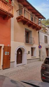 un bâtiment avec un balcon sur le côté d'une rue dans l'établissement La Maison du Coeur - Family Holiday, à Oulx