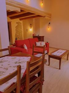- un salon avec un canapé rouge et des tables dans l'établissement La Maison du Coeur - Family Holiday, à Oulx
