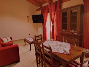 un salon avec une table, des chaises et une télévision dans l'établissement La Maison du Coeur - Family Holiday, à Oulx