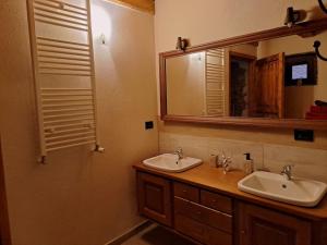 une salle de bain avec deux lavabos et un miroir dans l'établissement La Maison du Coeur - Family Holiday, à Oulx 10 autres photos