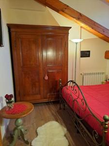 une chambre avec un lit et une table avec une couverture rouge dans l'établissement La Maison du Coeur - Family Holiday, à Oulx