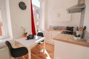 een keuken met een tafel en een klok aan de muur bij Lille centre- Nice and bright equipped studio in Lille