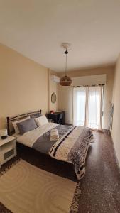 a bedroom with a large bed and a window at Sea side apartment in Loutraki