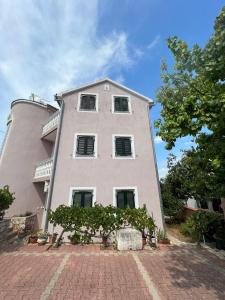 a large white building with windows on a brick road at Villa Sunce in Jezera