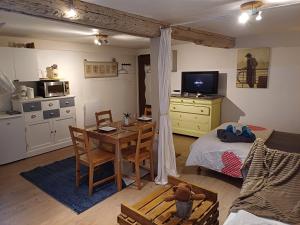een kleine woonkamer met een tafel en een keuken bij LE GITE in Colmar