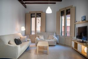 a living room with two couches and a tv at AT137 Abadia in Torredembarra