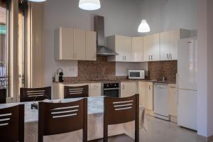 a kitchen with white cabinets and a table with chairs at AT137 Abadia in Torredembarra