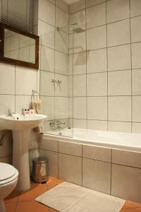 a bathroom with a tub and a toilet and a sink at Hendersons Lodge Ltd in Senekal