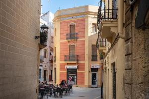 a group of people sitting at tables in an alley at AT137 Abadia in Torredembarra