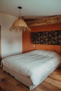 een slaapkamer met een bed met een oranje muur bij Ma Petite Bastide in Sainte-Bazeille