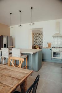 een keuken met een tafel en stoelen en een keuken met een fornuis bij Ma Petite Bastide in Sainte-Bazeille
