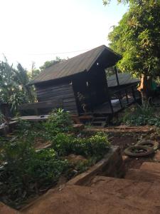 a house with a black roof and a yard at New Happy Elephant Bungalows 