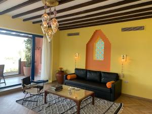 uma sala de estar com um sofá preto e uma mesa em Lazib Inn Resort & Spa em ‘Izbat an Nāmūs