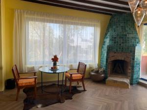een woonkamer met een tafel en een open haard bij Lazib Inn Resort & Spa in ‘Izbat an Nāmūs