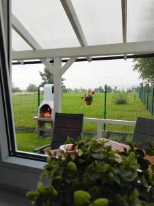 eine Terrasse mit einem Tisch, Stühlen und einem Grill in der Unterkunft Domki 7 Houses Rewal in Rewal