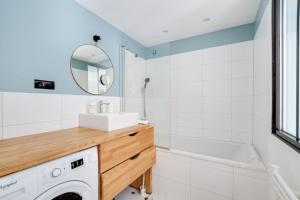 a bathroom with a sink and a washing machine at Lille Centre - Superb 60m2 2bed apartment ! in Lille