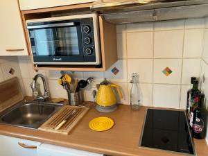 a kitchen counter with a sink and a microwave at Superbe studio idéalement situé à Flaine Forum in Flaine