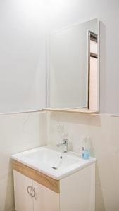 y baño con lavabo blanco y espejo. en Airport Apartment M&A, en Nador