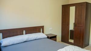 a bedroom with a bed with a wooden headboard and a mirror at Airport Apartment M&A in Nador