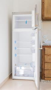an empty refrigerator with its door open in a kitchen at Airport Apartment M&A in Nador