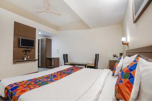 um quarto com uma cama grande e uma televisão em FabHotel Amman em Agra
