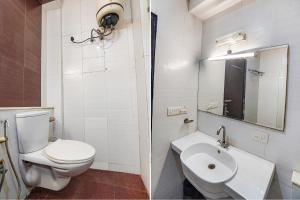 a white bathroom with a toilet and a sink at FabHotel Amman in Agra