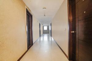einen Flur mit einem langen Korridor mit weißen Wänden in der Unterkunft FabHotel Amman in Agra