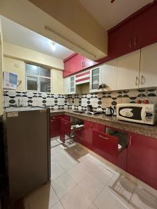 加濟阿巴德的住宿－Royal Ambience，一间厨房,配有红色橱柜和台面