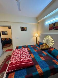 a bedroom with a large bed with a colorful blanket at Royal Ambience in Ghaziabad