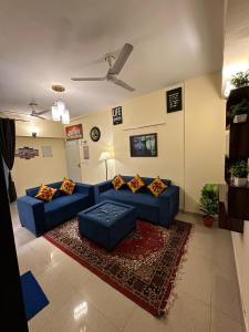 uma sala de estar com sofás azuis e um tapete em Royal Ambience em Ghaziabad