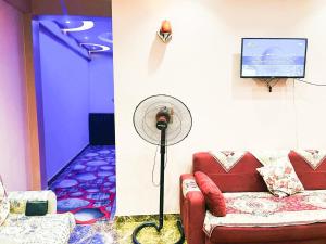 uma sala de estar com um sofá vermelho e uma ventoinha em شقة مميزة بجوار كورنيش النيل اسوان - عائلات فقط em Aswan